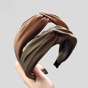 Close-up of knotted wide fabric headbands in caramel brown and olive green colors