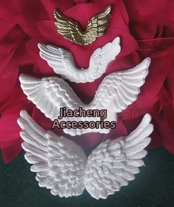 Detailed feather texture on white and gold plastic angel wings for Christmas crafts