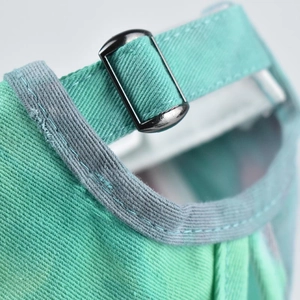 Detail of adjustable metal slide buckle and stitching on mint tie-dye sun hat
