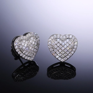 Macro shot of silver heart stud earrings with cubic zirconia pavé on a black background