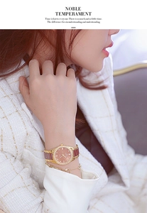 Close-up of a women's gold diamond-encrusted watch with a coffee ceramic strap on wrist