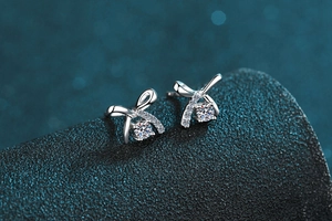 Macro view of silver bow-shaped stud earrings with transparent sparkling cubic zirconia