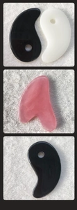 Macro view of heart and fish-shaped resin gua sha tools on a soft white towel