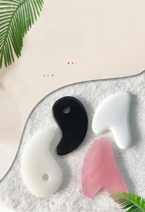 Detail view of resin heart and tai chi shaped guasha tools for body massage