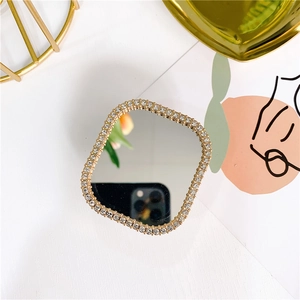Detail of square vanity mirror with rhinestones and gold base on a luxury white background