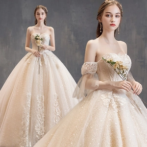 Detail of champagne bridal gown with floral lace embroidery and detachable puff sleeves