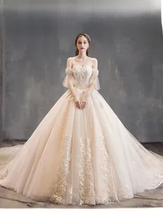 Detail of off-shoulder lace embroidery on a champagne ball gown wedding dress