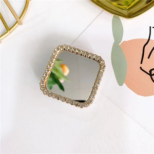 Close-up of square gold phone grip with rhinestone border and reflective mirror surface