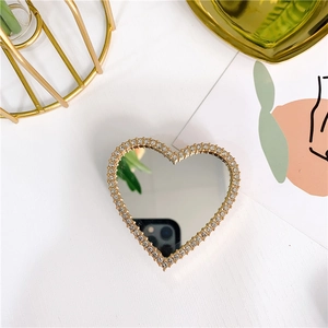 Close-up of heart-shaped phone grip with gold metallic frame and sparkling rhinestones