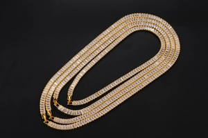 Detailed view of coiled gold-plated tennis chain with rectangle-cut cubic zirconia stones