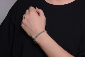 Close-up of a silver cuban link bracelet with baguette-cut diamonds on a male wrist