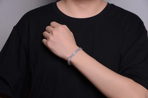 Close-up of a silver-toned hip hop cuban link bracelet with rectangular clear crystals
