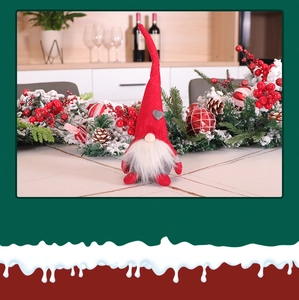 Nahaufnahme einer Weihnachtswichtel-Puppe mit roter Mütze auf einem festlichen Tisch