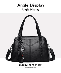 Close-up of black lychee leather tote bag with V-shaped stitching and cat charm detail