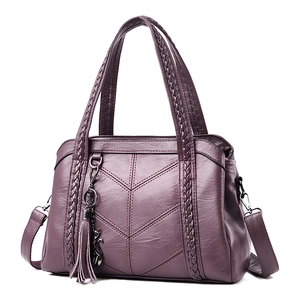 Purple leather tote bag for women with woven handles and cat tassel at a 45-degree angle