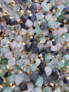 Macro view of assorted natural raw gemstone pendants with elegant golden metal caps