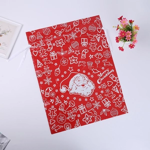 Macro view of a red Merry Christmas drawstring gift bag with Santa Claus patterns