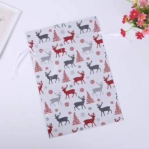 Detailed view of Christmas drawstring gift bags featuring reindeer and snowflake patterns