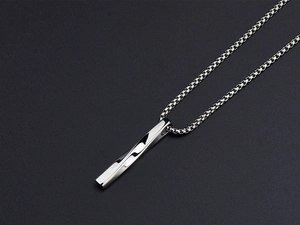 Macro shot of silver twisted bar pendant necklace on black background with box chain details