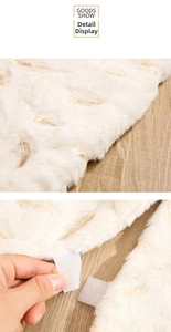 Detail of white faux fur Christmas tree skirt with gold feathers and velcro fastener