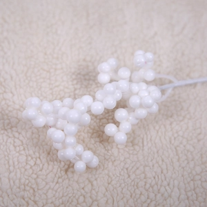 Artificial white berry picks for Christmas decoration on a soft beige fabric background