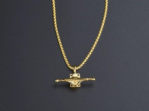 Close-up of golden skateboard truck pendant necklace with textured steel square chain