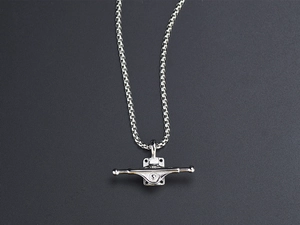 Macro shot of silver skateboard truck pendant with a polished box chain necklace