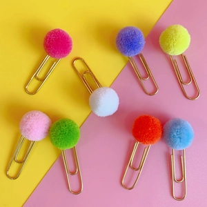Close-up of eight colorful pompom paper clips in gold metal on a vibrant background