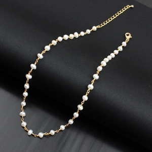 Macro detail of the gold-plated chain and natural egg-shaped freshwater pearl on necklace