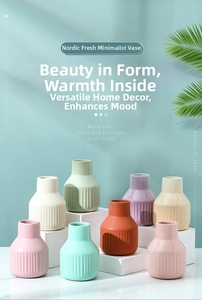 Close-up of minimalist ceramic vases with vertical stripes in multiple pastel colors