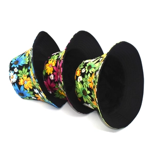 Three cotton daisy print bucket hats in black with blue, pink and green floral patterns