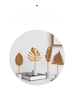 Modern gold monstera leaf metal sculpture with white marble base for home decor