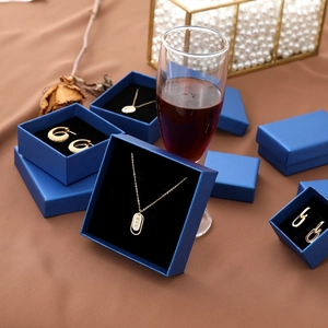 Peacock blue jewelry gift box set with gold necklace and earrings on brown satin fabric