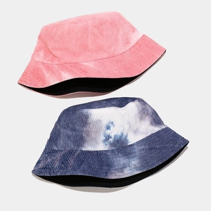 Flat lay of pink and blue tie-dye corduroy bucket hats with black interior lining
