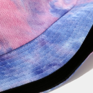 Detailed close-up of tie-dye corduroy fabric texture on a pink and blue bucket hat
