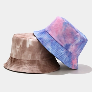 Detailed close-up of tie-dye corduroy bucket hats in brown, blue and pink patterns