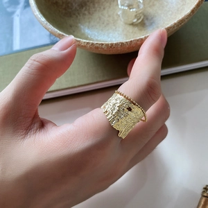 Detail of wide gold 925 silver ring featuring crumpled texture and bead chain edge