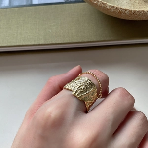 Irregular textured gold wide band ring with a delicate bead chain on hand