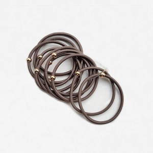 Dettaglio di elastici per capelli con perline dorate e texture elasticizzata senza cuciture
