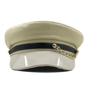 Detail of military flat top cap with cream leather, black band and gold chain decoration