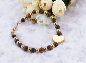 Detailed shot of tiger eye stone heart bead bracelet on a white plush background
