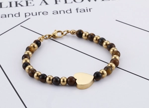 Detail of tiger eye stone heart bracelet with gold beads and lobster clasp on card