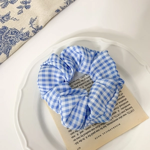 Chouchou à carreaux vichy bleu et blanc sur une assiette décorative en porcelaine