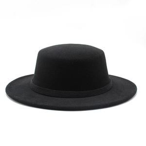 Close-up of a black flat top wool felt hat with matching ribbon and wide brim