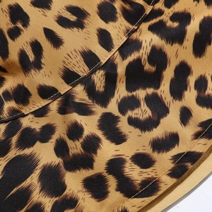 Close-up of leopard print fabric showing detailed twill texture of the bucket hat