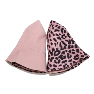 Detail of reversible pink leopard bucket hat and solid pink cotton sun hat on white background