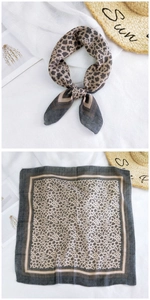 Close-up of leopard print linen scarf tied elegantly and laid flat with summer hat
