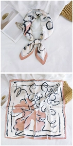 Detailed view of square silk scarf with vine prints and pink borders on satin fabric
