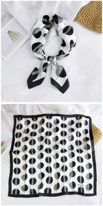 Detailed view of square silk scarf with black and white polka dot pattern and rolled edges