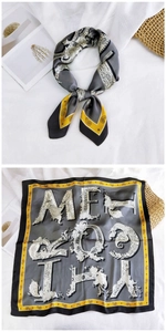 Detail of square silk scarf with paisley pattern, yellow edges and letter print design